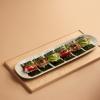 Slider of sushi on a pale wooden table